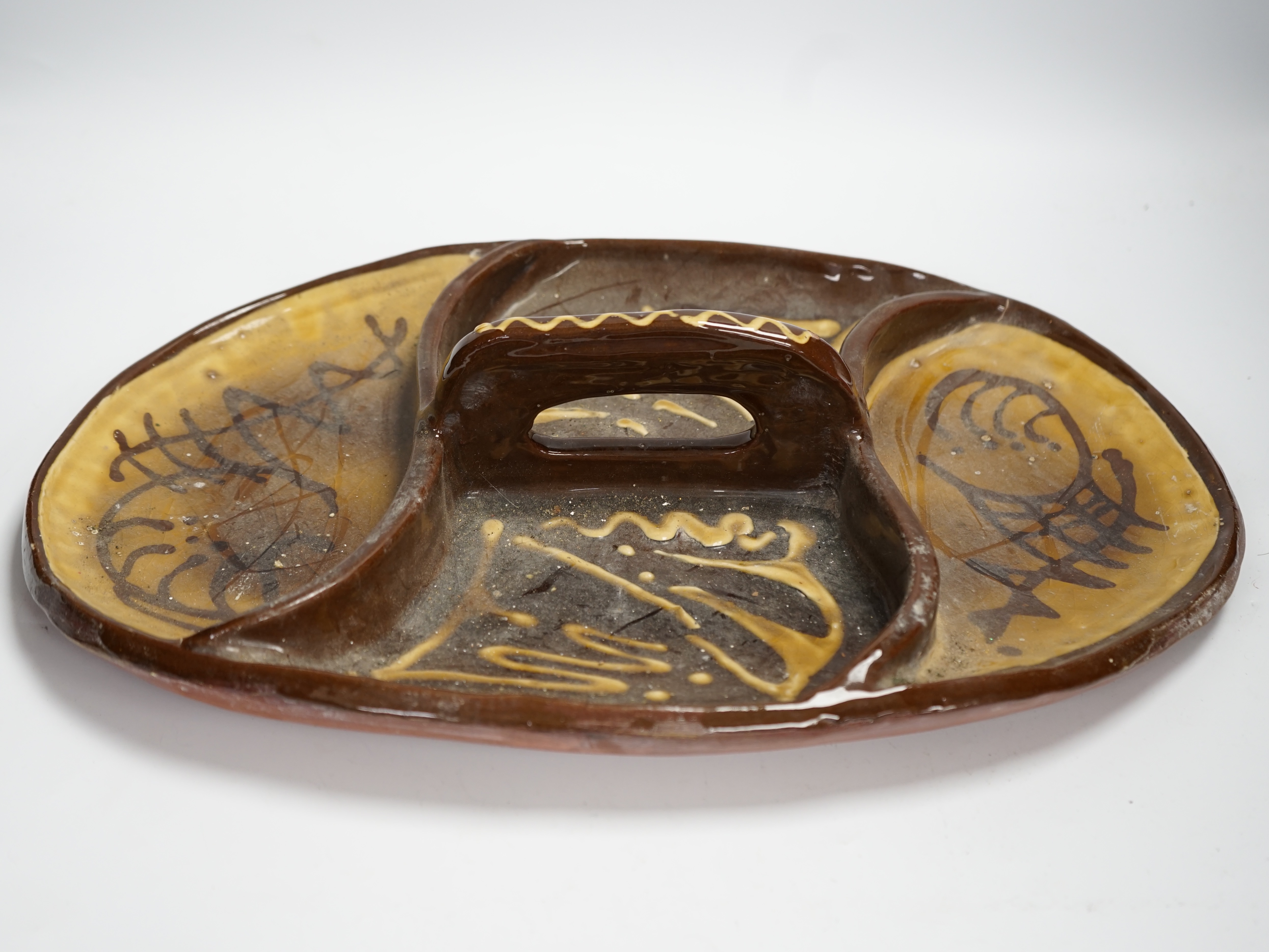 A set of nine studio pottery plates together with a slipware dish, 46cm long